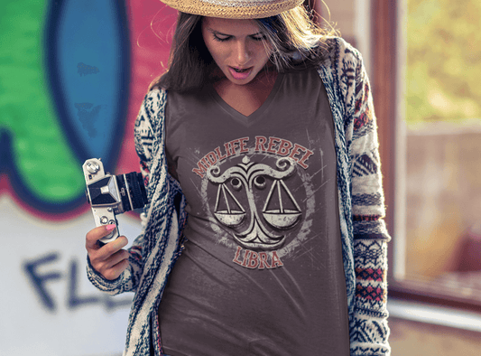 Woman wearing Libra scales zodiac t-shirt with abstract design, holding a camera, stylish streetwear outfit, astrology apparel.