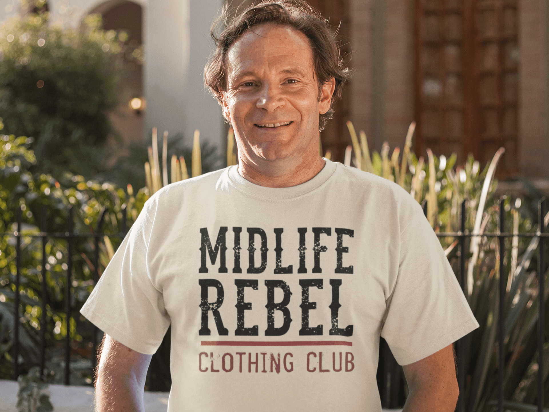 Midlife-Rebel-Clothing-Club-Logo-middle-aged-man-wearing-a-round-neck-tshirt-while-outdoors