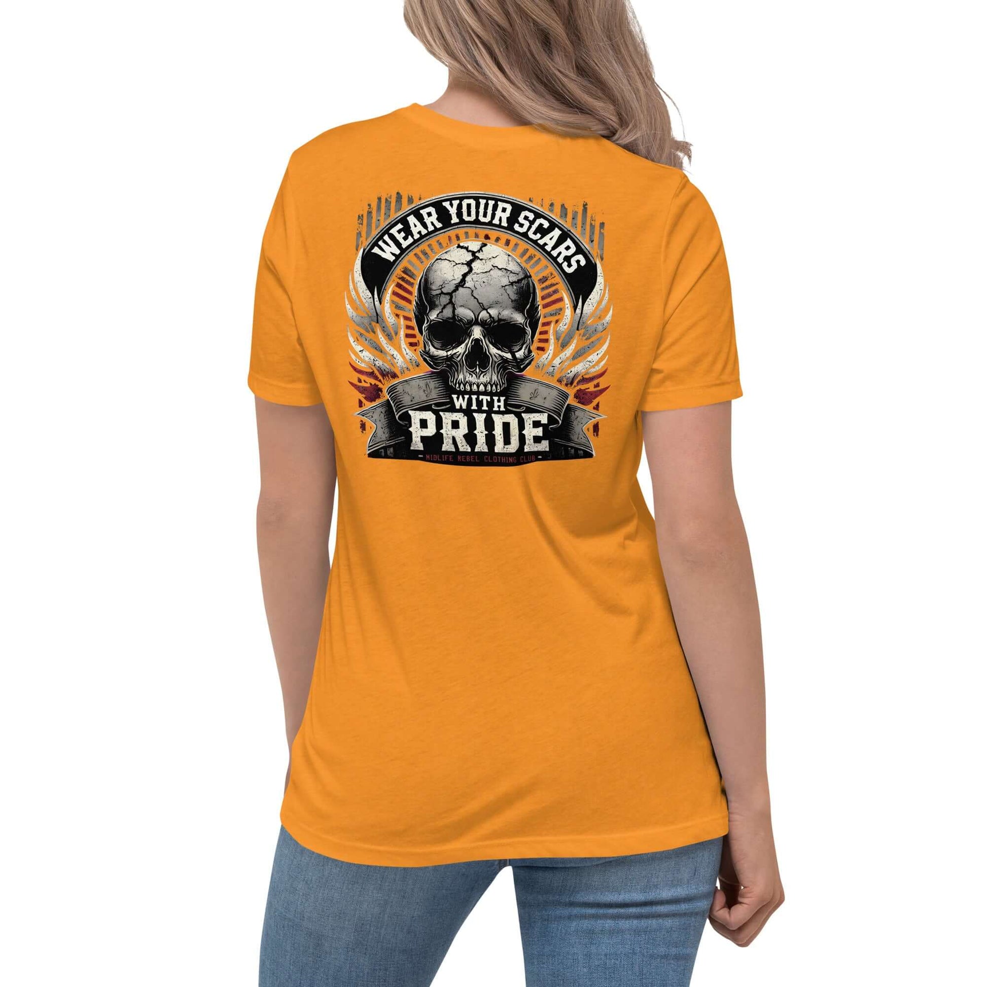 Woman wearing orange "Wear Your Scars With Pride" T-shirt featuring a skull and wings design, showcasing resilience and strength.